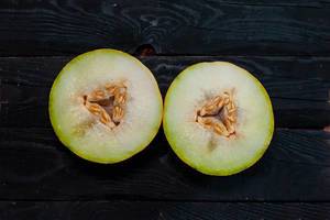 Two slice of sweet melon on the dark wooden background (Flip 2020)