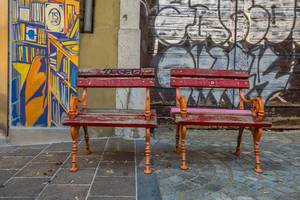 Two small benches near mural on the wall