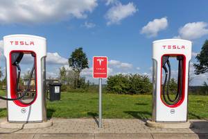 Two Tesla Supercharger Stations - electric vehicle charging network, in front of blue sky
