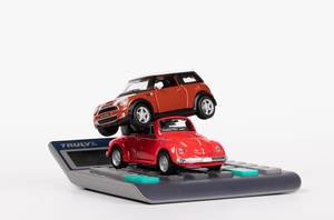 Two toy cars on calculator