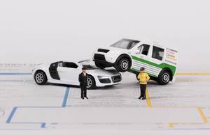 Two toy cars with policeman on accident statement report