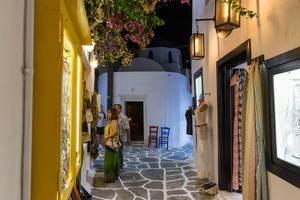 Typisch griechische, schmale Gasse mit Pflastersteinen und Verkaufsgeschäften in Naoussa auf Paros
