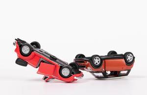 Unfall mit roten Spielzeugautos auf weißem Hintergrund