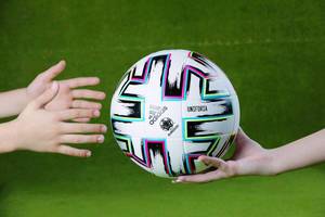Uniforia ball in hands of supporters, EURO 2020, green background
