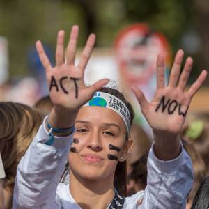 United for climate strike: girl protests climate politics, "Act Now" written on her hands