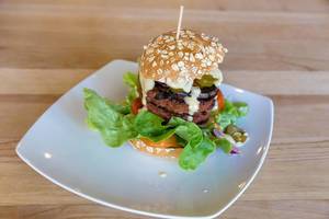 Unkonventionelles veganes Burger mit Beyond Meat Patty auf weißem Teller