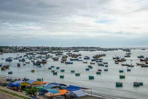 Unzählige traditionell runde Fischerboote und Holzboote im Hafen von Mui Ne, Vietnam