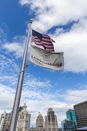 US-Fahne und Fahne vom LondonHouse Chicago Luxury Riverfront Hotel wehen im Wind