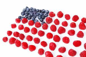USA flag made of blueberries and raspberries, white background