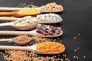 Various cereals and legumes in wooden spoons (Flip 2019)