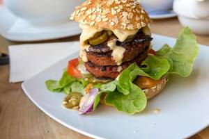 Vegan, animal-free burger with Beyond Meat and fresh vegetables in close-up