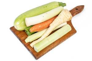 Vegetables on the cutting board isolated above white background