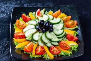 Vegetarian salad with lettuce, tomatoes, cucumber and olives