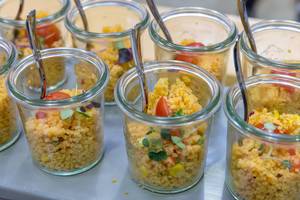 Vegetarisches Couscous-Salat mit Tomaten, Mais, roten Zwiebeln und Keimen in Gläschen auf dem BarCamp Bonn