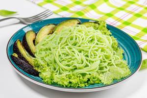 Vegetarisches Mittagessen mit grüner Spaghetti, Avocado und Salat