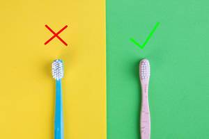 Vergleich von Zahnbürsten aus Kunststoff und Bambus, auf gelbem und grünem Hintergrund