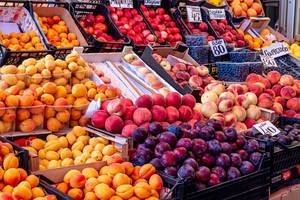 Verkaufsauslage verschiedener Beeren und Sommerfrüchte wie Aprikosenund Pfirsiche
