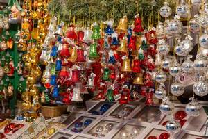 Verkaufsauslage von bunten Weihnachtsbaumkugeln und -glocken an Weihnachtsmarkt