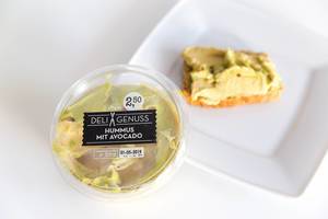 Verpackung von "Deli Genuss" enthält den veganen Brotaufstrich Hummus mit Avocado