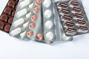 Verschiedene Medikamente in Blister-Verpackungen vor weißem Hintergrund