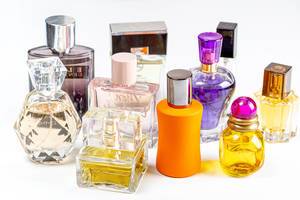 Verschiedene Parfümflaschen und gefüllte Flakons vor hellem Hintergrund