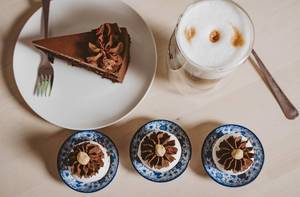 Verschiedene Schokokuchen als Desserts, neben einem Milchkaffee