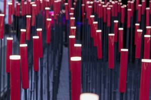 Viele Stehlampen aus roten eckigen Zylindern auf Metallstäben künstlerisch fotografiert
