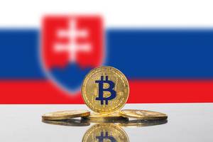 Vier Bitcoins, eine Kryptowährung, vor der Flagge der Slovakei