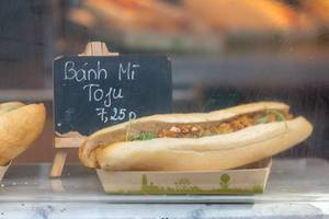 Vietnamese booth offers vegetarian Bánh Mí sandwichwith tofu and vegetables on compostable paper plate at Tomorrowland festival