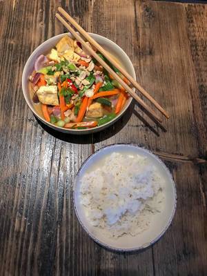 Vietnamesisches Gemüse-Gericht mit Reis auf Holztisch mit Essstäbchen