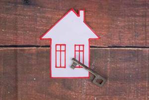 Vintage-Haustürschlüssel liegt auf einem selbstgemalten Haus