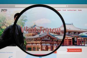 Visit Japan website on a computer screen with a magnifying glass