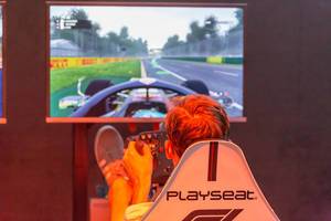 Visitor sitting in a Playseat gaming seat and playing F1 2018