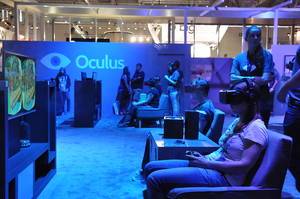Visitors of the Gamescom fair in Cologne using Oculus Rift Virtual Reality headsets