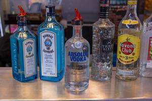 Vodka, Gin und Rum: Alkohol in Flaschen mit Ausgießer-Aufsatz auf einer Theke
