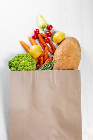 Volle Papier-Einkaufstüte mit gesunden Lebensmitteln für eine vegane Ernährung