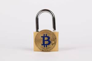 Vorhängeschloss mit goldenem Bitcoin vor weißem Hintergrund