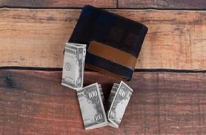 Wallet with dollar banknotes on wooden table