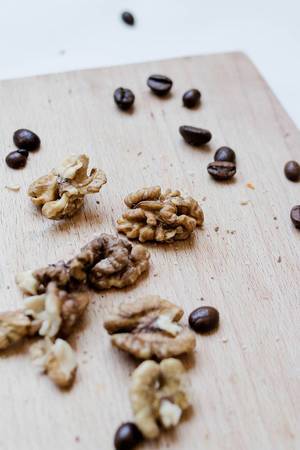 Walnuts and coffee beans on wood board
