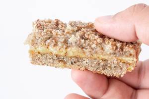 Walnuts Cake slice in the hand above white background (Flip 2019)