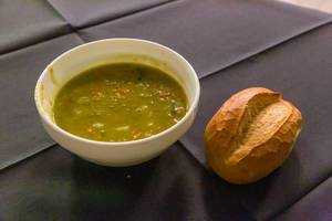 Warme Erbsensuppe mit Brötchen als einfaches Mittagessen auf dem Weihnachtsmarkt