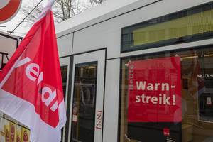 Warnstreik-Poster an einer Straßenbahn und eine Verdi-Fahne