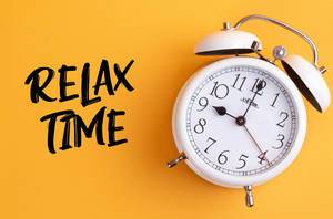Wecker mit dem Text ‘Relax time’ vor gelbem Hintergrund
