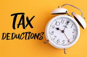 Wecker mit dem Text ‘Tax deductions’ vor gelbem Hintergrund