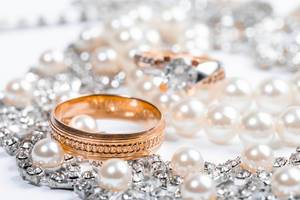 Wedding rings and bride necklace with pearls close up (Flip 2019)