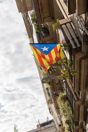 Wehende Estelada Flagge an einem gotischen Balkon in Barcelona, Spanien,  ist ein Symbol für die Unabhängigkeit Kataloniens