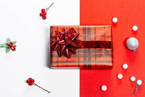 Weihnachtlicher roter und weißer Hintergrund mit verpacktem Geschenk Top-view