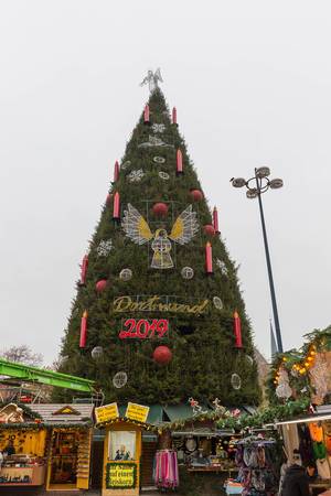Weihnachtsmarkt in Dortmund am Hansaplatz: Geschmückter Weihnachtsbaum mit großen Adventskerzen und Weihnachtsbaumkugeln