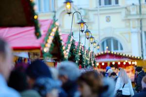 Weihnachtsmarkt Stände bei leichter Dämmerung mit Publikum