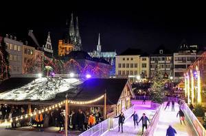 Weihnachtsstimmung bei den Schlittschuhläufern auf der Eisbahn, an einem deutschen Adventsmarkt